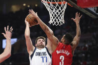 Dallas Mavericks guard Luka Doncic is fouled by Portland Trail Blazers guard CJ McCollum during the first half of an NBA basketball game in Portland, Ore., Wednesday, Jan. 26, 2022. (AP Photo/Amanda Loman)