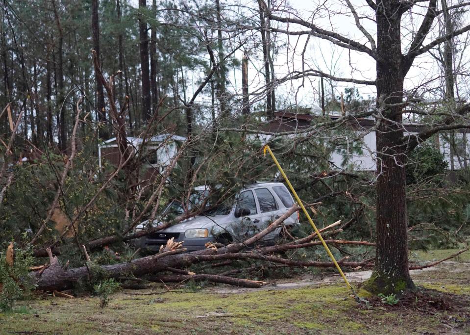 A vehicle is caught under downed trees along Lee Road 11 in Beauregard, Ala., Sunday, March 3, 2019, after a powerful storm system passed through the area. (Kara Coleman Fields/Opelika-Auburn News via AP) ORG XMIT: ALOPE131