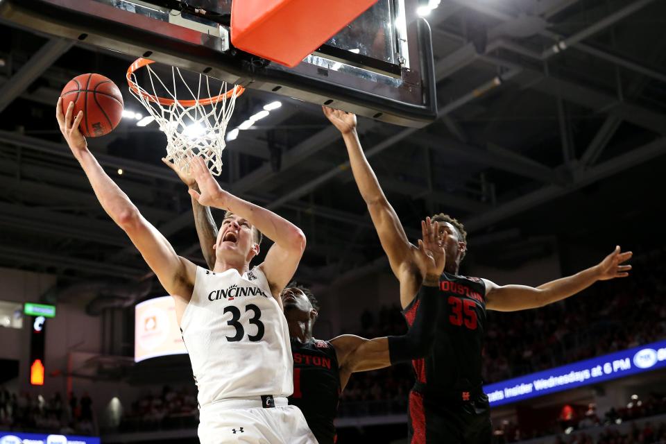 Cincinnati Bearcats center Chris Vogt (33) goes up for a basket as Houston Cougars forward Fabian White Jr. (35) defends in the first half during a college basketball game, Saturday, Feb. 1, 2020, at Fifth Third Arena in Cincinnati. 