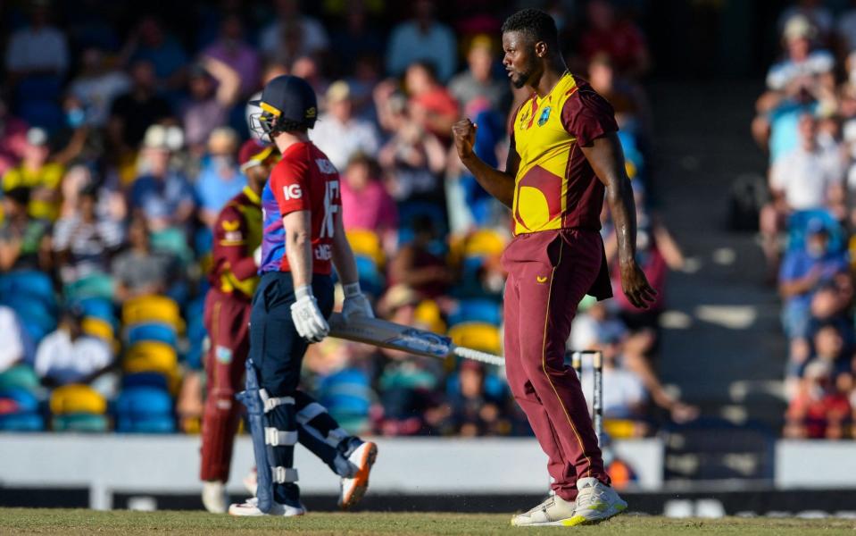 Romario Shepherd (R), of West Indies, celebrates the dismissal of Eoin Morgan  - AFP