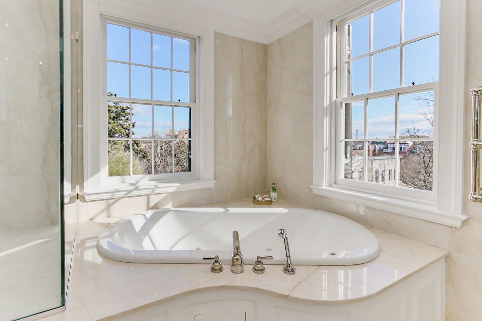 The master bathroom is covered in white marble, including the floors and walls.