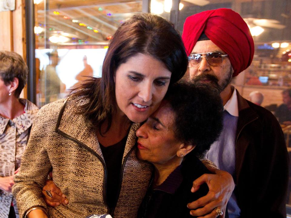 Nikki Haley with her parents. She hugs her mom with her dad in the background.