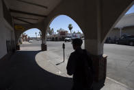 A man walks by nearly empty streets Wednesday, May 20, 2020, in Calexico, Calif. As much of California inches toward businesses reopening, this farming region on the state's border with Mexico is grappling with a spike in hospitalizations from the coronavirus that could inflict more pain on its perpetually struggling economy. (AP Photo/Gregory Bull)