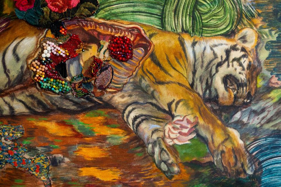 Beads spill out of a painting of a dissected tiger