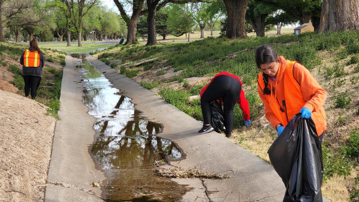 Volunteers clean up trash at Thompson Park during the cleanup event held in honor of Earth Day.