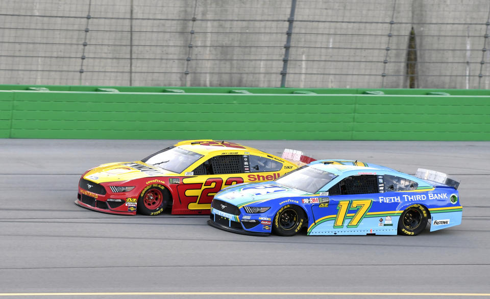 Joey Logano (22) tries to hold off Ricky Stenhouse Jr. (17) during the NASCAR Cup Series auto race at Kentucky Speedway in Sparta, Ky., Saturday, July 13, 2019. (AP Photo/Timothy D. Easley)