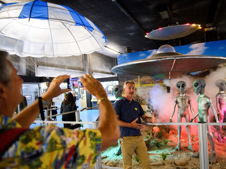 A visitor poses for a photo at the International UFO museum.