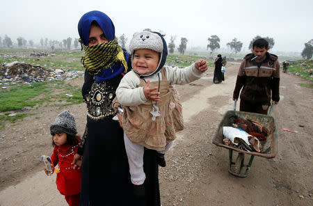Displaced Iraqi people from different areas in Mosul flee their homes to reach safe areas after clashes broke out as Iraqi forces battle with Islamic State militants in the city of Mosul. REUTERS/Youssef Boudlal