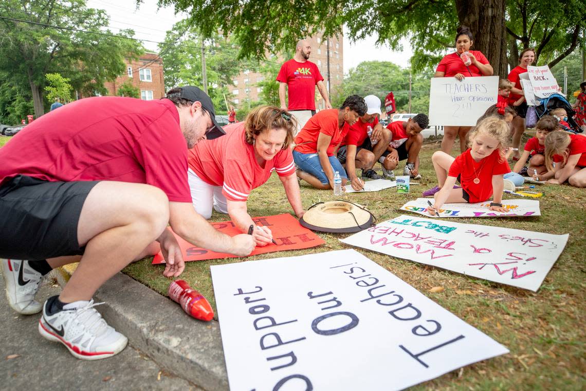 Zach Jordan, left, helps his mother, Pattie Clark, a retired art teacher, make signs for the SC for ED rally to the South Carolina State House Wednesday May 1, 2019, in Columbia. An estimated 10,000 students, teachers and advocates marched.