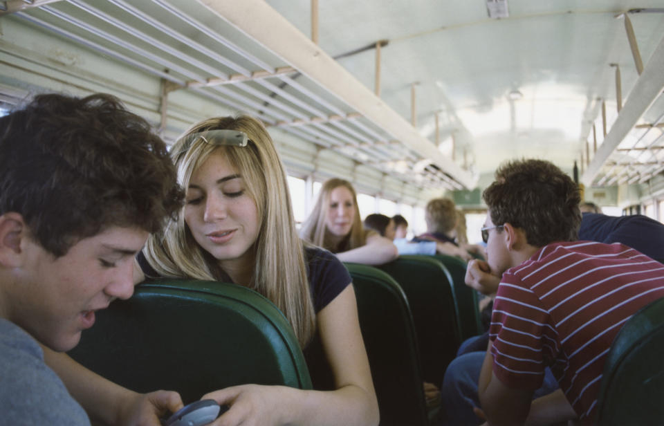 Students sitting and interacting on a school bus