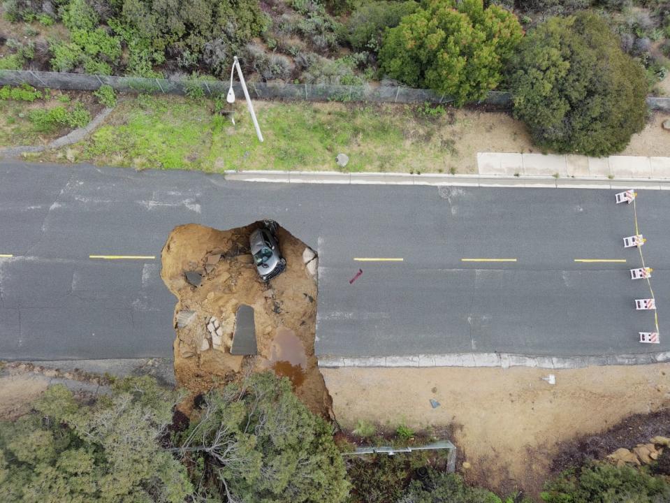 <div class="inline-image__caption"><p>This aerial view shows two cars siting in a large sinkhole that opened during a day of relentless rain, January 10, 2023 in the Chatsworth neighborhood of Los Angeles, California. </p></div> <div class="inline-image__credit">Robyn Beck via Getty</div>