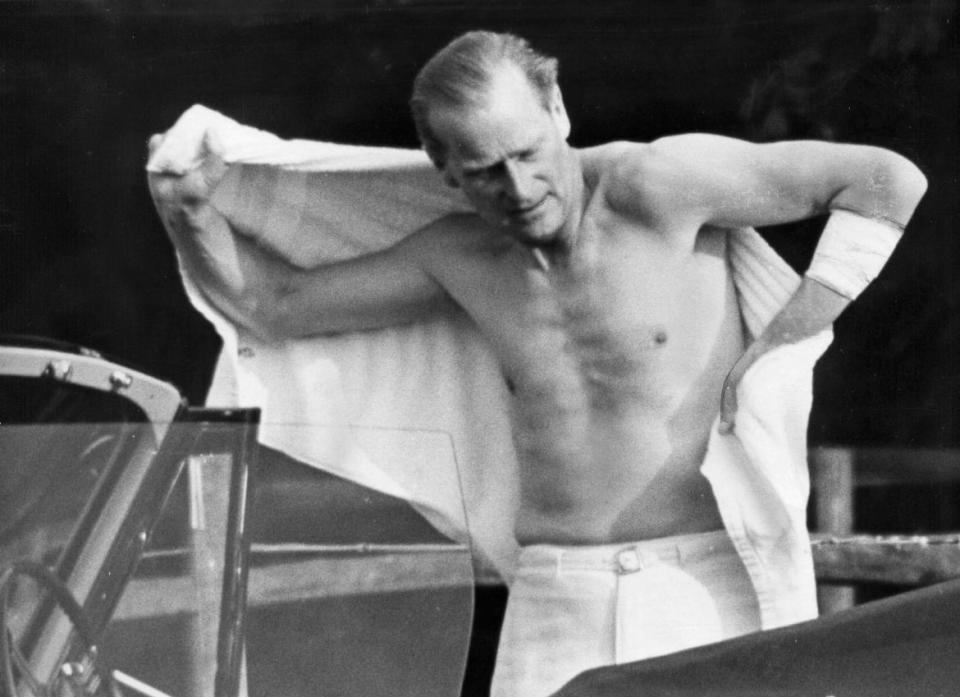 Prince Philip shirtless changing for polo. His arm bandaged up after injury. July 1963.