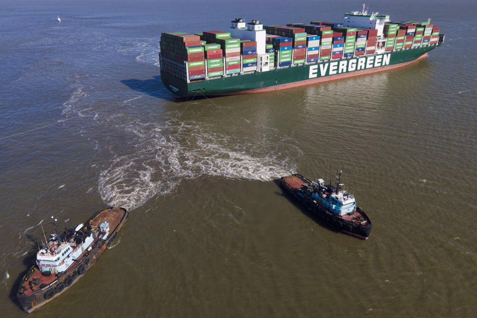 The tugboats Atlantic Enterprise, bottom left, and Atlantic Salvor, bottom right, use lines to pull the container ship Ever Forward, which ran aground in the Chesapeake Bay, as crews began to attempt to refloat the ship, Tuesday, March 29, 2022, in Pasadena, Md. (AP Photo/Julio Cortez)