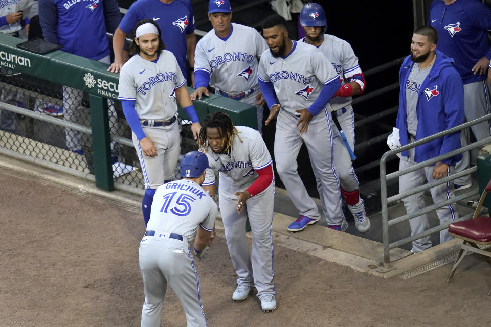 Toronto Blue Jays' Randal Grichuk celebrates his home run off Chicago White Sox starting pitcher Lance Lynn with Vladimir Guerrero Jr., as teammates watch during the second inning of a baseball game Wednesday, June 9, 2021, in Chicago. (AP Photo/Charles Rex Arbogast)