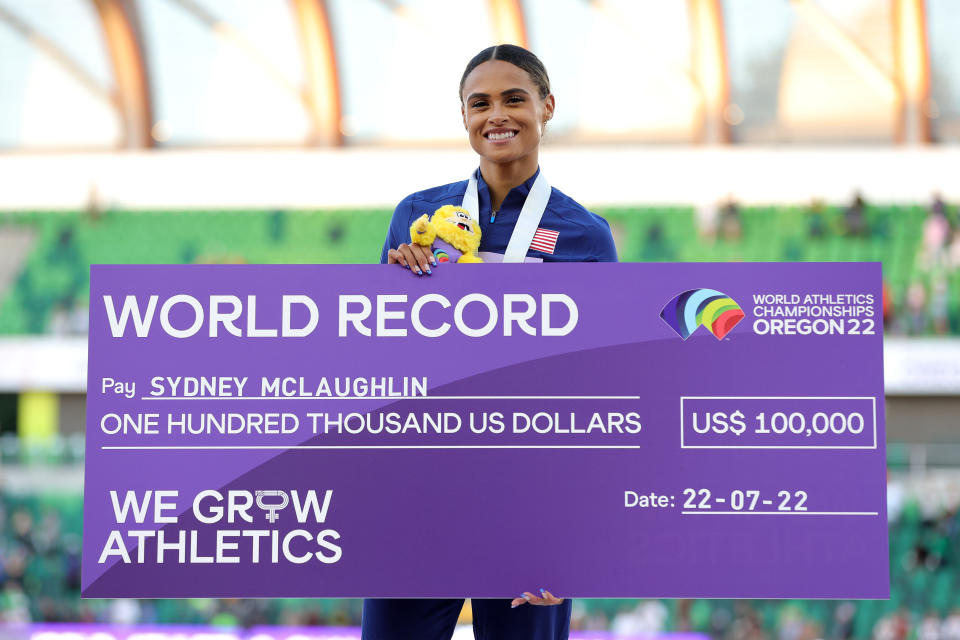 Sydney McLaughlin, pictured here with her gold medal and a $100,000 cheque for setting a new world record.