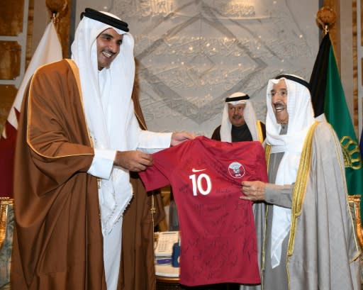 Qatar's ruler Emir Sheikh Tamim bin Hamad al-Thani hands his Kuwaiti counterpart Emir Sheikh Sabah al-Ahmad Al-Sabah a signed Qatari national team jersey in a display of the alliances at play in the Gulf