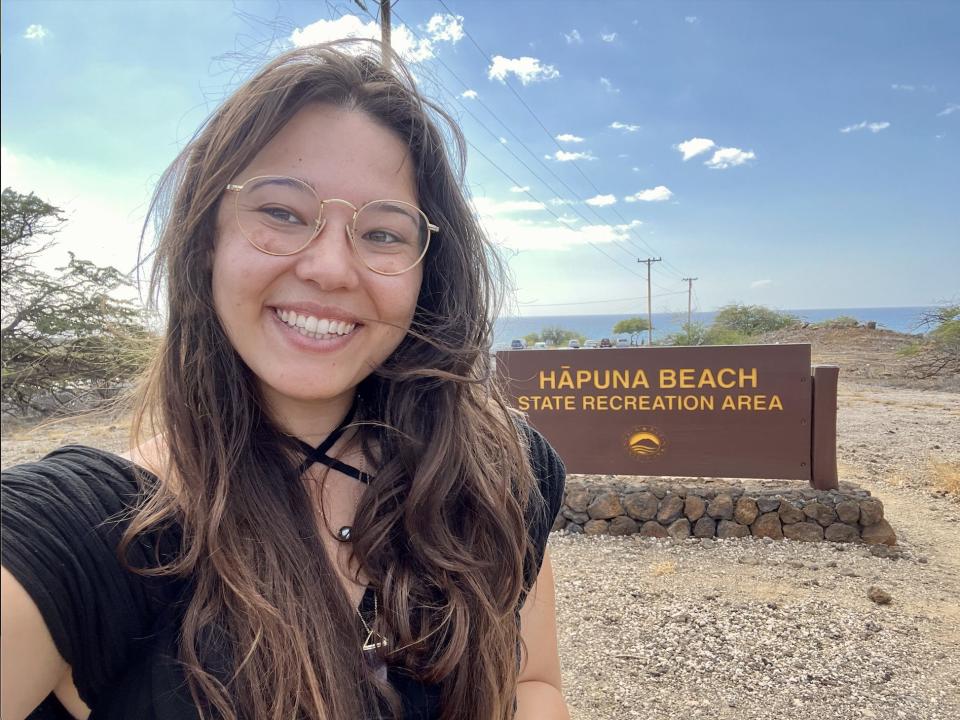 The writer taking a selfie in front of brown hapuna beach sign