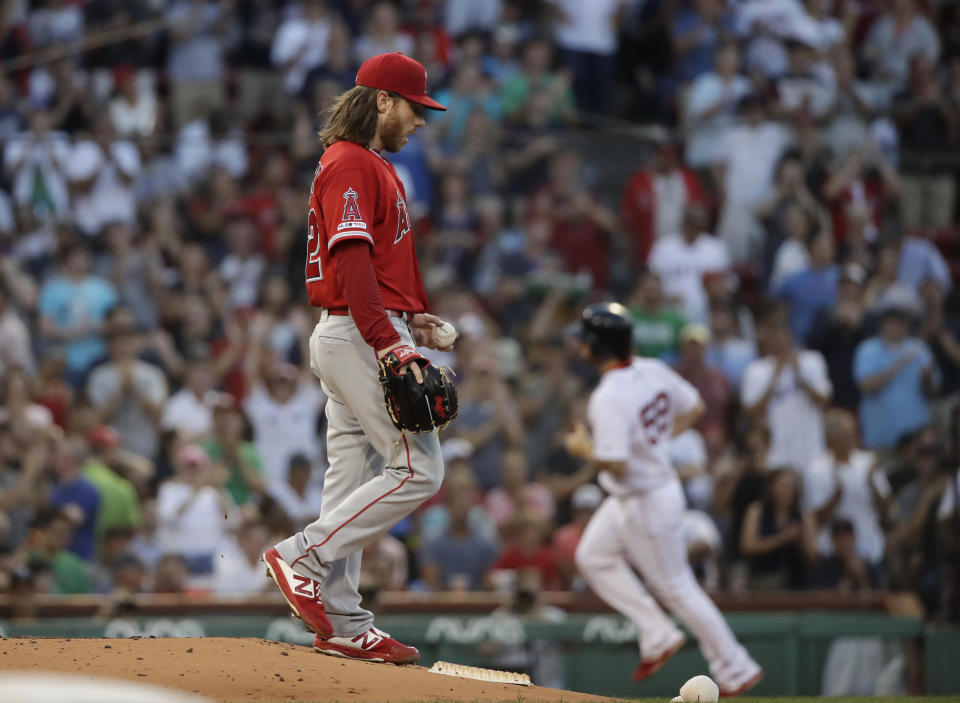 Los Angeles Angels starting pitcher Dillon Peters walks on the mound as Boston Red Sox's Sam Travis rounds the bases after hitting a two-run home run during the second inning of a baseball game at Fenway Park, Thursday, Aug. 8, 2019, in Boston. (AP Photo/Elise Amendola)