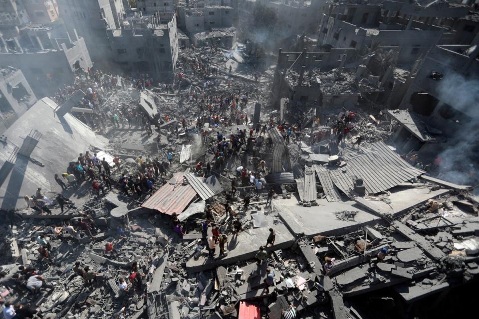 Palestinians inspect the rubble of destroyed buildings following Israeli airstrikes on town of Khan Younis, southern Gaza (AP)