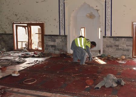 A rescue worker collects evidence after an explosion in a Shi'ite mosque in Shikarpur, located in Pakistan's Sindh province January 30, 2015. REUTERS/Amir Hussain