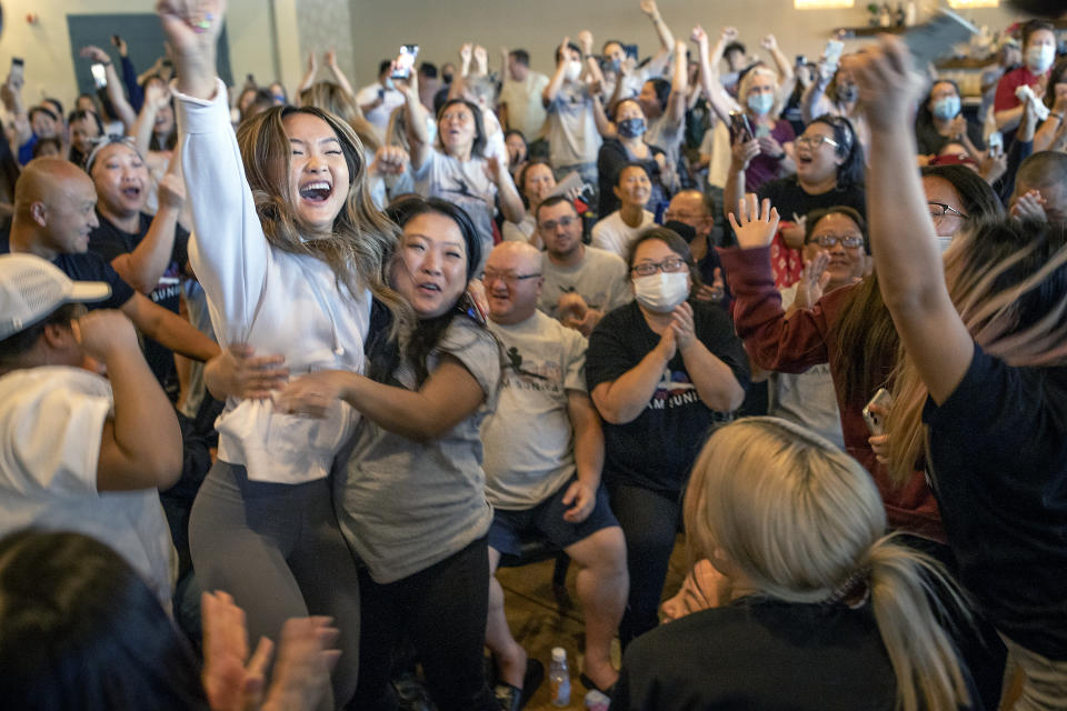 Shyenne Lee, 18, left foreground, the older sister of St. Paul Olympian Sunisa Lee, reacts alongside Souayee Vang and other family and friends as they watch Sunisa Lee clinch the gold medal in the women's Olympic gymnastics all-around at the Tokyo Olympics Thursday, July 29, 2021 in Oakdale, Minn. (Elizabeth Flores/Star Tribune via AP)