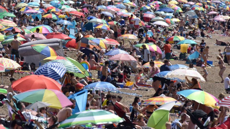 Personas tomando el sol en una playa en Reino Unido este domingo.