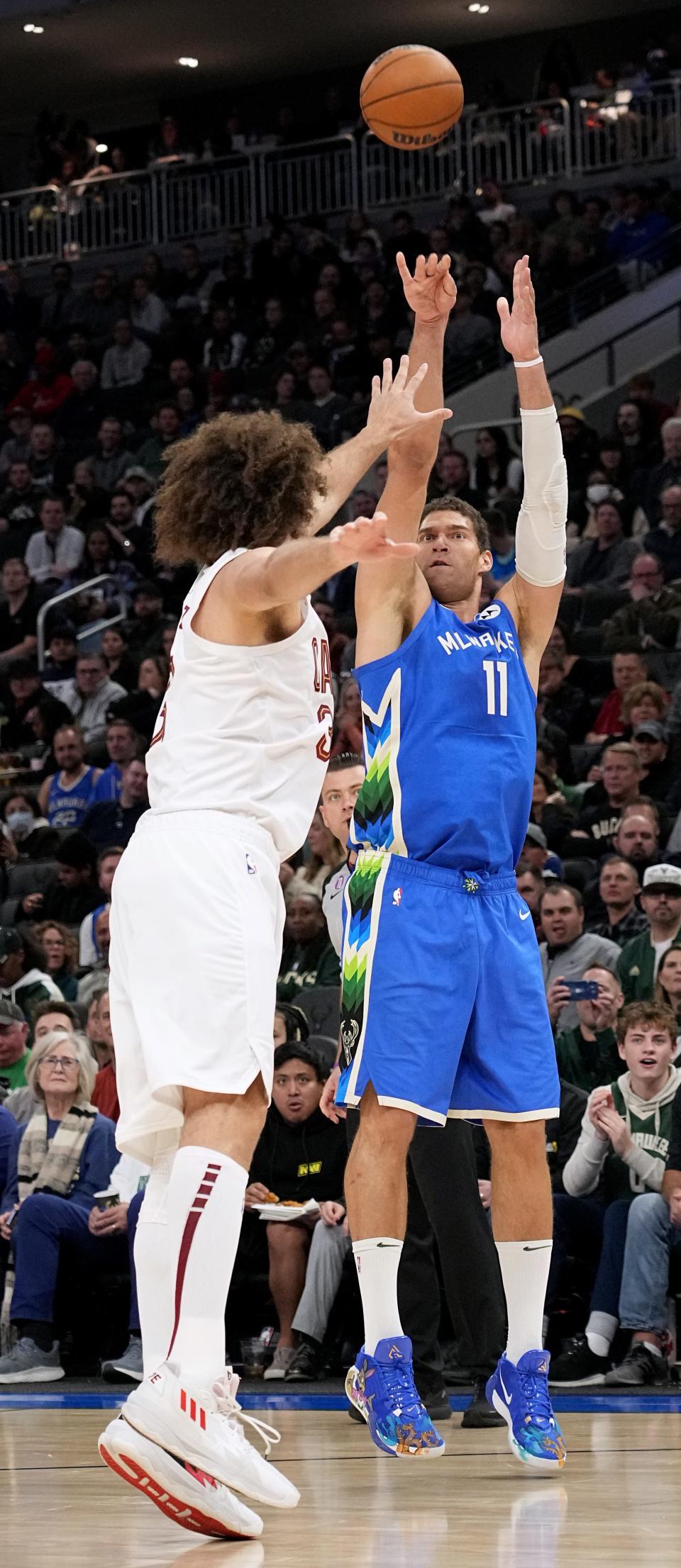 A file photo of Milwaukee Bucks center Brook Lopez (11) shooting over his brother, then Cleveland Cavaliers center Robin Lopez (33) during a game on Nov. 16, 2022 at Fiserv Forum in Milwaukee. Now, the brothers both play for the Bucks.