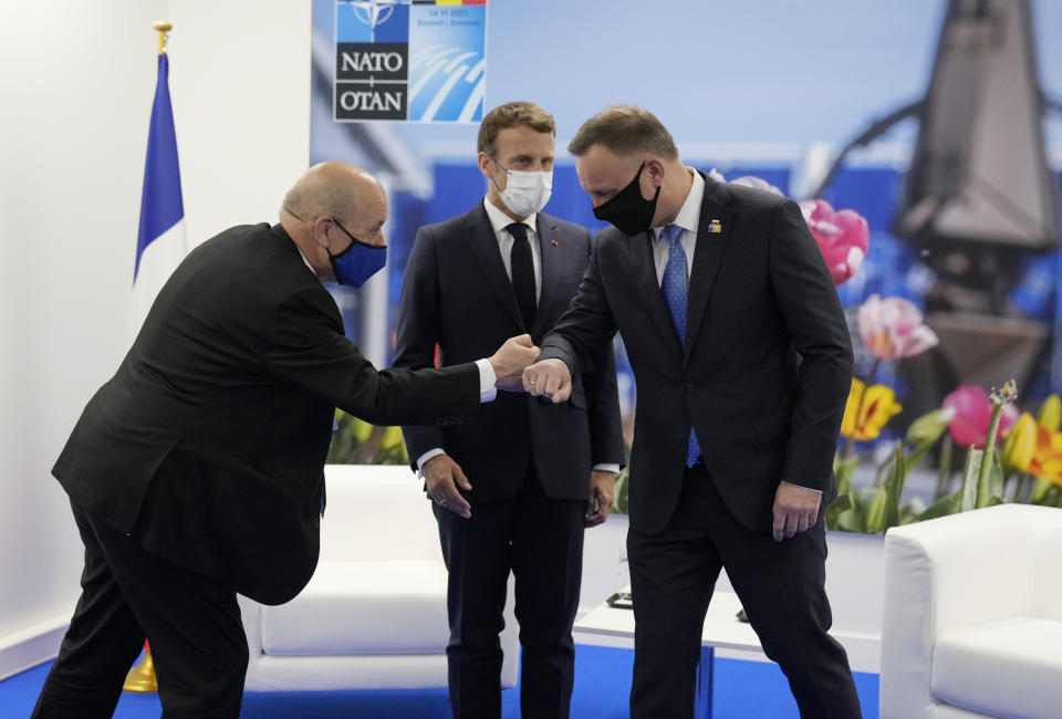 French President Emmanuel Macron, center, and French Foreign Minister Jean-Yves Le Drian greet Poland's President Andrej Duda during a bilateral meeting on the sidelines of a NATO summit at NATO headquarters in Brussels, Monday, June 14, 2021. U.S. President Joe Biden is taking part in his first NATO summit, where the 30-nation alliance hopes to reaffirm its unity and discuss increasingly tense relations with China and Russia, as the organization pulls its troops out after 18 years in Afghanistan. (AP Photo/Francois Mori, Pool)