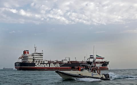 A speedboat of the Iran's Revolutionary Guard moves around a British-flagged oil tanker Stena Impero, which was seized on Friday by the Guard, in the Iranian port of Bandar Abbas, - Credit: AP