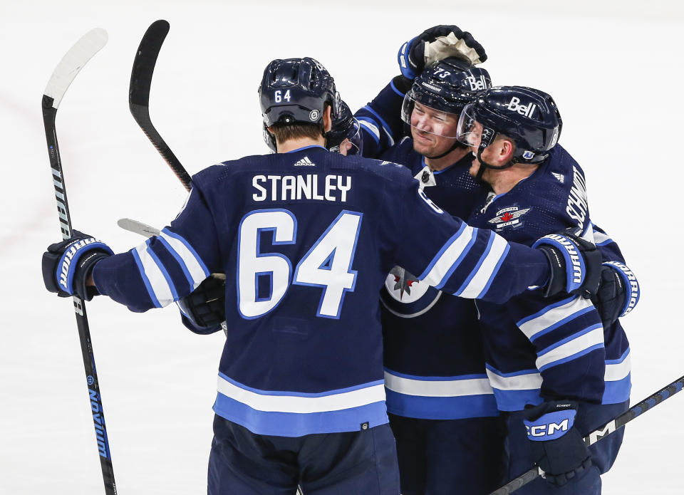 Winnipeg Jets' Logan Stanley (64), Nikolaj Ehlers (27), Tyler Toffoli (73) and Nate Schmidt (88) celebrate after Toffoli's first goal against the Anaheim Ducks' during third-period NHL hockey game action in Winnipeg, Manitoba, Friday, March 15, 2024. (John Woods/The Canadian Press via AP)