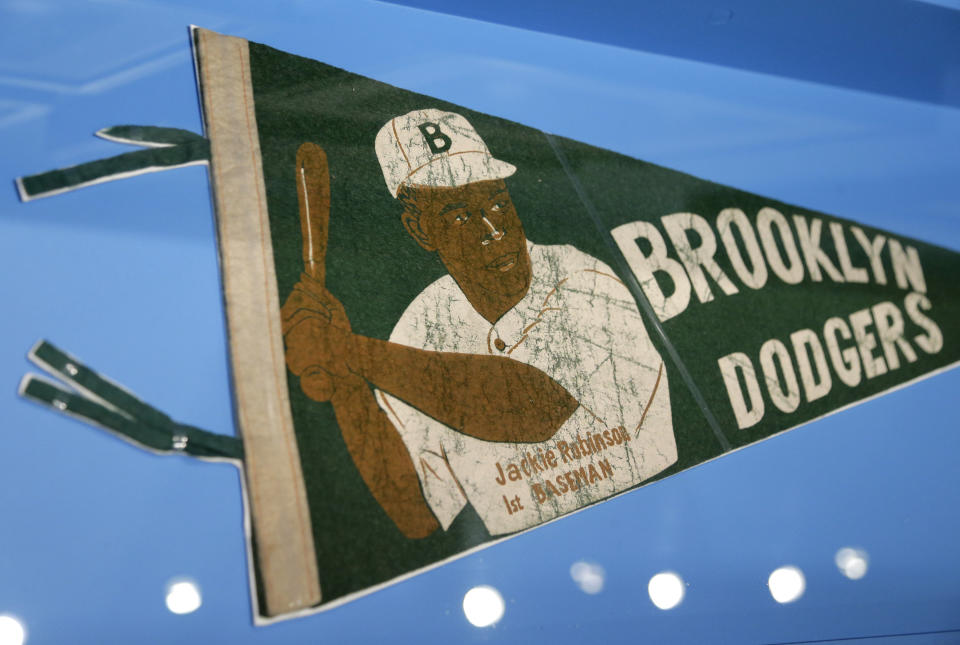 FILE - A banner with a picture of Brooklyn Dodgers baseball player Jackie Robinson is displayed at the exhibit "In the Dugout with Jackie Robinson: An Intimate Portrait of a Baseball Legend" at the Museum of City of New York in New York, Jan. 29, 2019. Already at the forefront on the 75th anniversary of breaking baseball’s color barrier, Jackie Robinson’s life, legacy and impact is honored as part of the 2022 baseball All-Star Game in Los Angeles. (AP Photo/Seth Wenig, File)