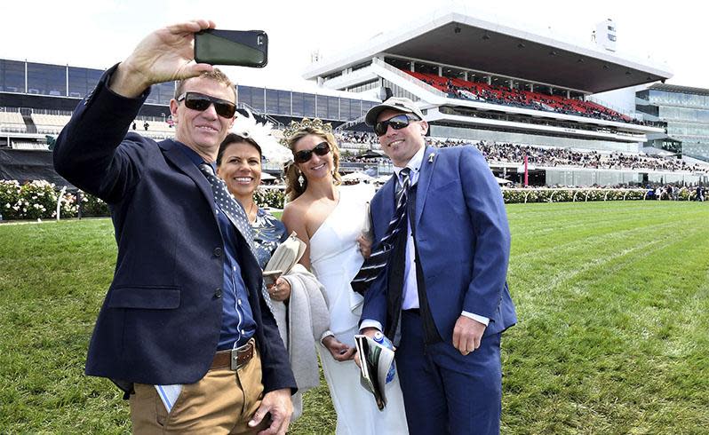 <p>Pictured: Punters brave wild weather as Melbourne Cup festivities get underway</p>