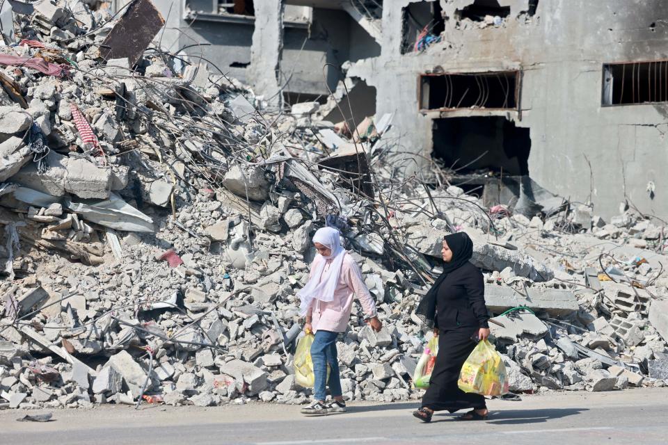 Palestinian evacuees walk amid the rubble of destroyed buildings in central Gaza Strip on their way south on Nov. 5, 2023.