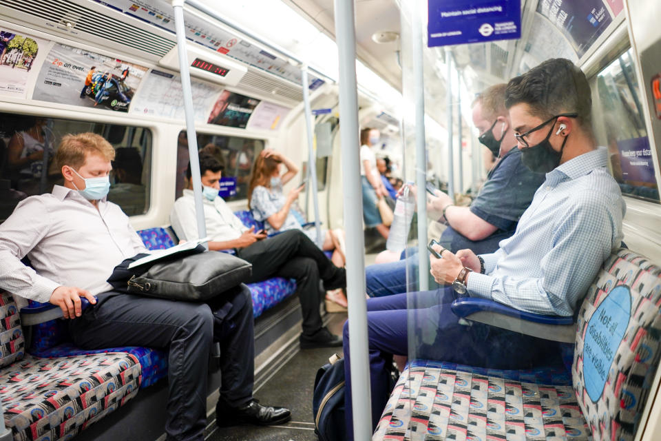 People sit on an Underground train, in London, Monday, July 19, 2021. As of Monday, face masks are no longer legally required in England, and with social distancing rules shelved, there are no limits on the number of people attending theater performances or big events. (AP Photo/Alberto Pezzali)