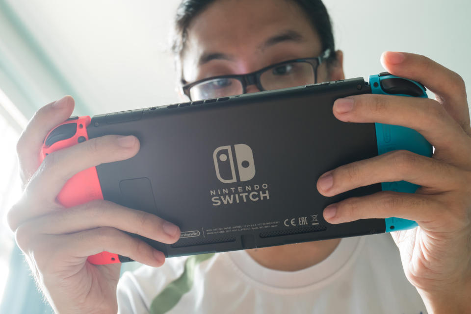 Homem jogando seu Nintendo Switch.