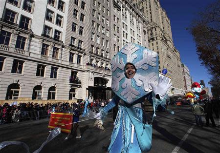 A performer waves as she walks along Central Park West during the 87th Macy's Thanksgiving Day Parade in New York November 28, 2013. REUTERS/Gary Hershorn