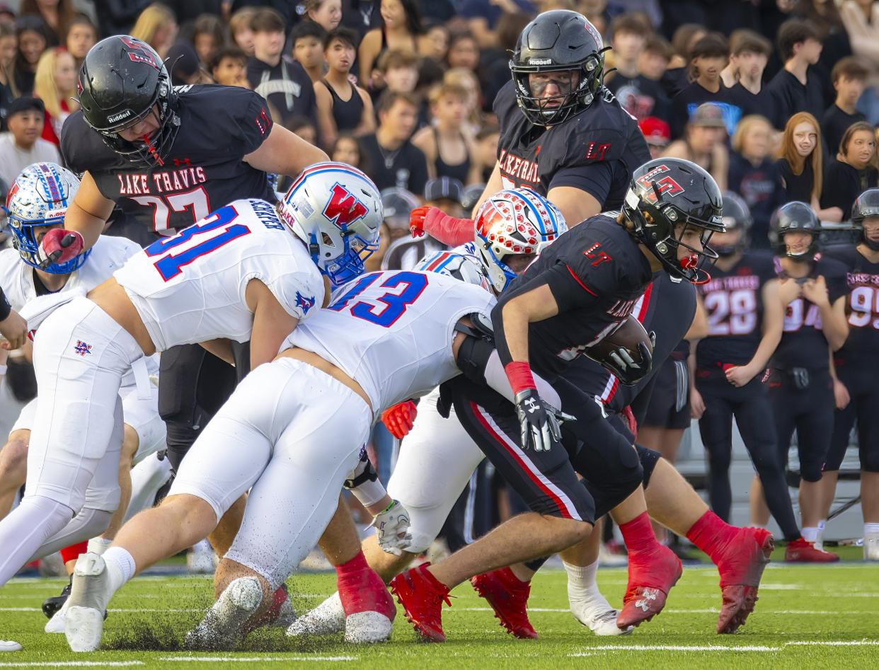 Lake Travis running back Kadyn Leon tries to break free from several Westlake defenders during the Chaparrals' 21-14 state quarterfinal playoff victory at The Pfield in Pflugerville on Saturday.
