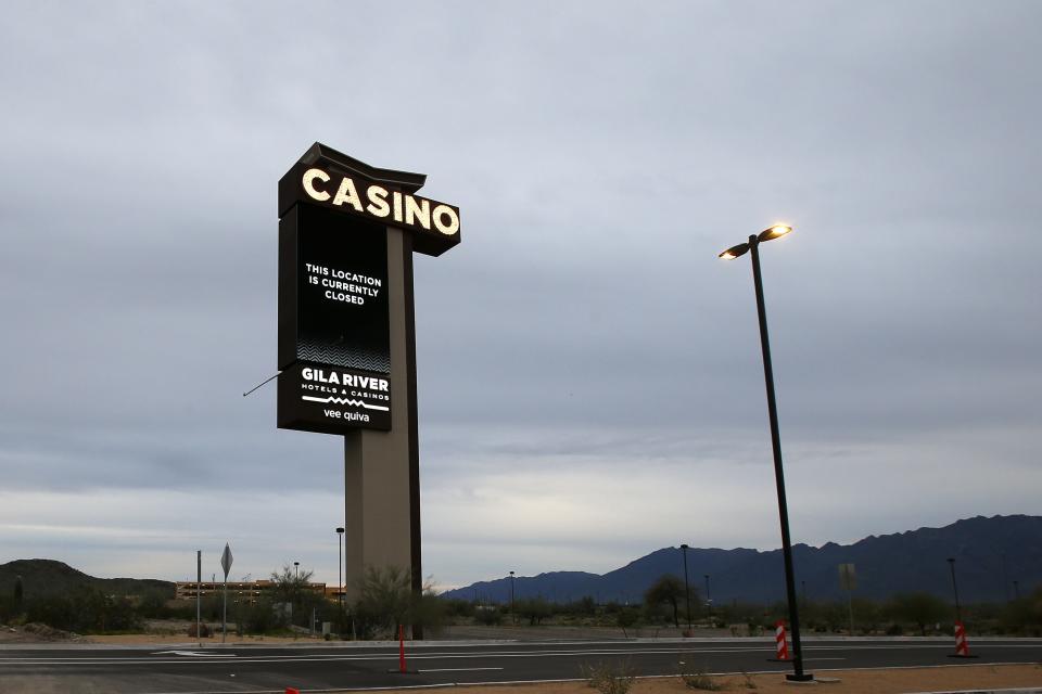 A sign shows the Gila River Hotels & Casinos Vee Quiva location closed due to the coronavirus Friday, March 20, 2020, in Laveen, Ariz. Native American tribes across the U.S. have been closing their properties, with all casinos in the Phoenix metro area closing down. (AP Photo/Ross D. Franklin)