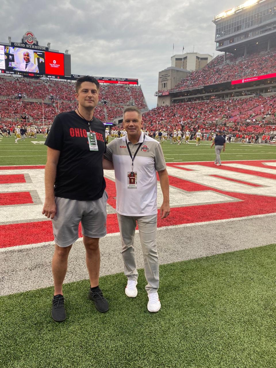 Ohio State coach Chris Holtmann takes a photo with Patrick Behan, a high school basketball coach and lifelong Buckeyes fan, prior to a football game against Notre Dame at Ohio Stadium on Sept. 3, 2022.