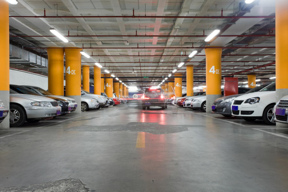 An underground garage with moving and parked cars