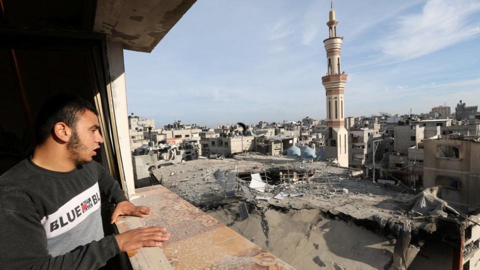 A Palestinian man looks at the remains of the al-Huda mosque in Rafah, in the southern Gaza Strip, which was reportedly destroyed in an Israeli strike during an operation to rescue hostages (12 February 2024)