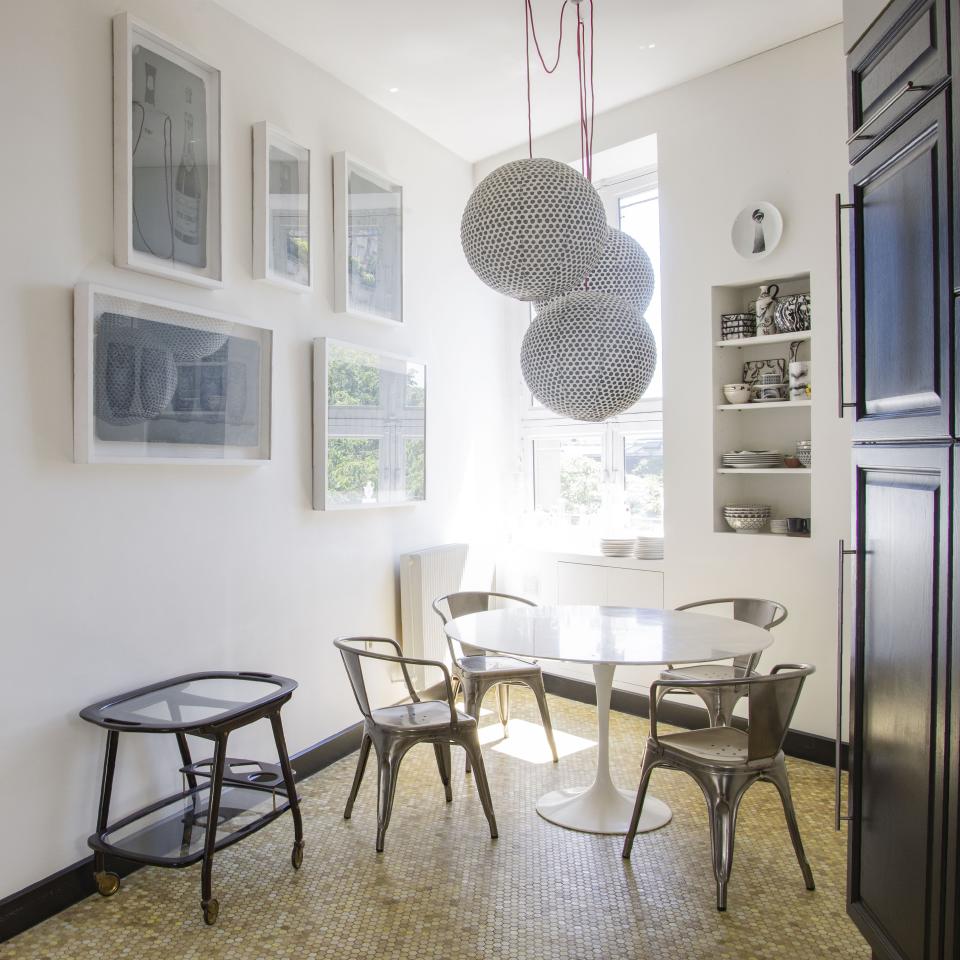 The kitchen table is Knoll and the chairs are Tolix. The vintage trolley is Italian from the 1950s, and on the wall are original zinc prints by Fornasetti.