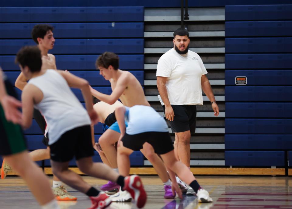 Winnacunnet boys basketball assistant coach Seth Provencher monitors players running sprints during Tuesday's practice.