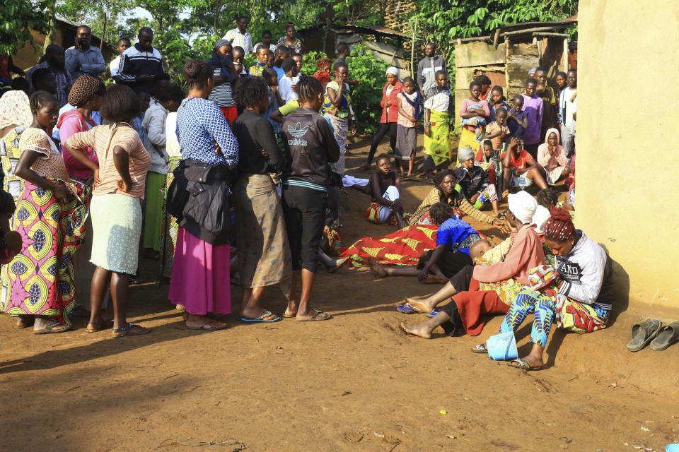 In this photo taken Friday, Oct 5, 2018, family members and onlookers mourn over the bodies of civilians killed by The Allied Democratic Forces rebels in Beni, Eastern Congo. Congo’ military said Sunday Oct. 21, 2018, that rebels attacked an Ebola treatment centre in Beni, leaving over a dozen civilians dead and abducted about a dozen children, which could force crucial virus containment efforts to be suspended in the area. (AP Photo/Al-hadji Kudra Maliro)