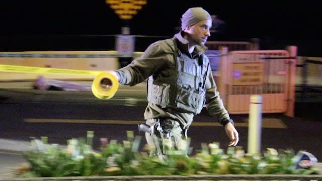 An officer winds police tape around the crime scene after RCMP confirmed a body of man had been found near the waterfront of White Rock, B.C., on Tuesday, April 23, 2024. 