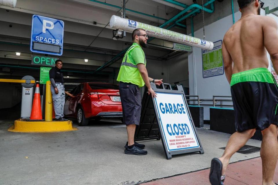 Jorge Latil, vigilante de estacionamiento, e Yvane Saint Jean, guardia de seguridad, vigilan después de que el City Garage 1 cerrara para todos, excepto los habitantes de Miami Beach y los empleados de los negocios locales, el jueves 7 de marzo de 2024. La mayoría de los estacionamientos públicos al sur de 42 Street estarán completamente cerrados este fin de semana por las vacaciones de primavera en Miami Beach, Florida.