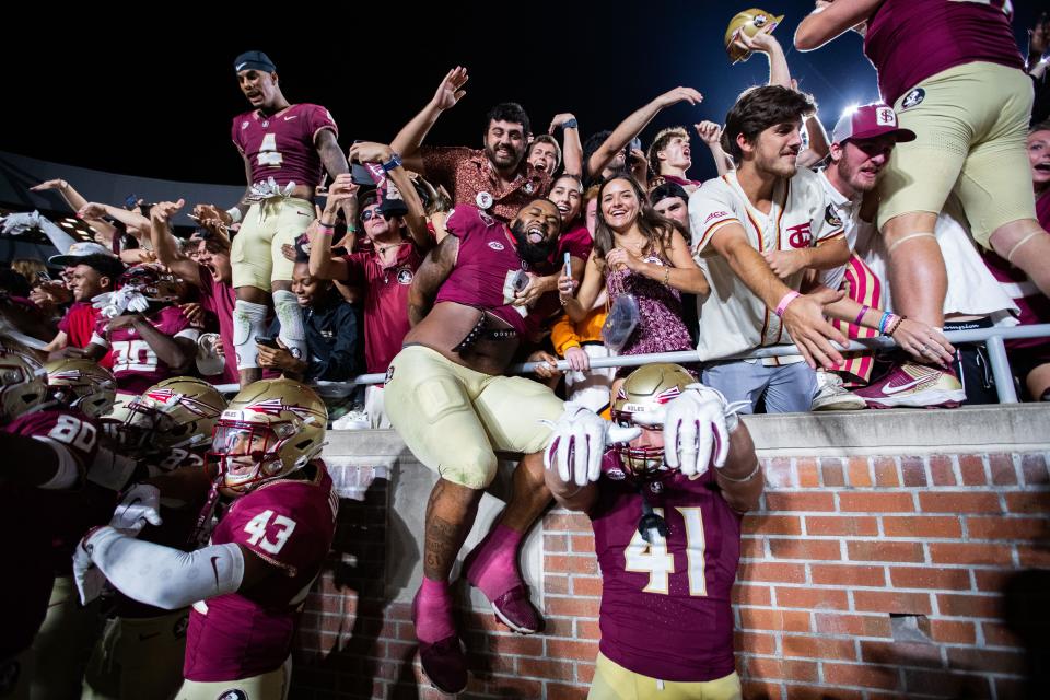 Florida State football players celebrate their 27-20 victory over Miami with the student section on Saturday, Nov. 11, 2023.