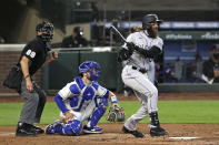 Colorado Rockies' Charlie Blackmon, right, watches the path of his single as Seattle Mariners catcher Joe Hudson, center, and umpire Cory Blaser look on in the fourth inning of a baseball game Sunday, Aug. 9, 2020, in Seattle. (AP Photo/Elaine Thompson)