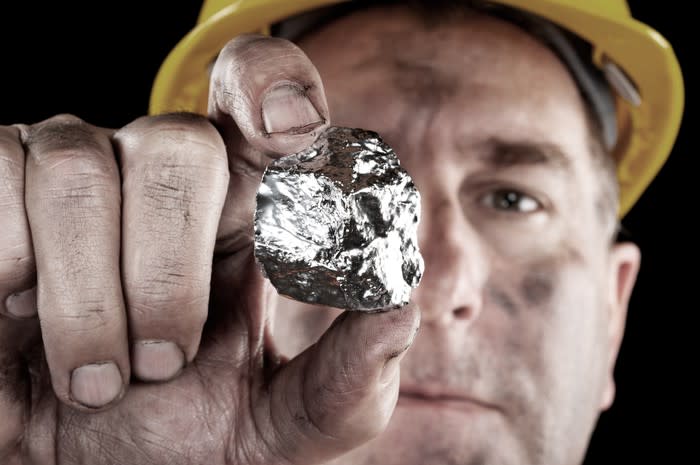 Miner holing a nugget of silver.