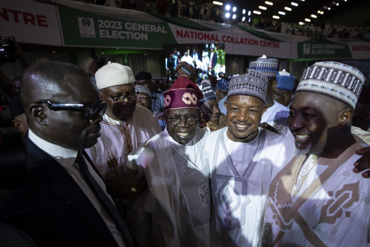President-Elect Bola Tinubu, center-left, is congratulated by party dignitaries after receiving his certificate at a ceremony in Abuja, Nigeria, Wednesday, March 1, 2023. Election officials declared Tinubu the winner of Nigeria’s presidential election Wednesday, keeping the ruling party in power in Africa’s most populous nation. (AP Photo/Ben Curtis)